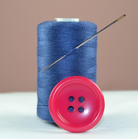 Spool of blue thread with a red button