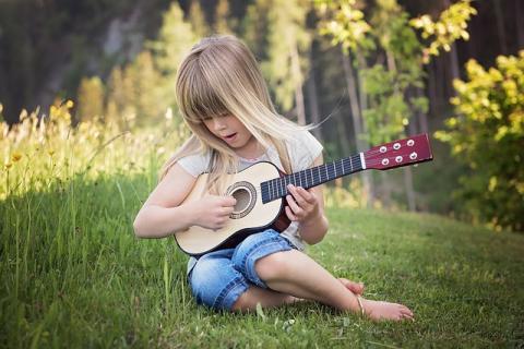 Child playing guitar and singing