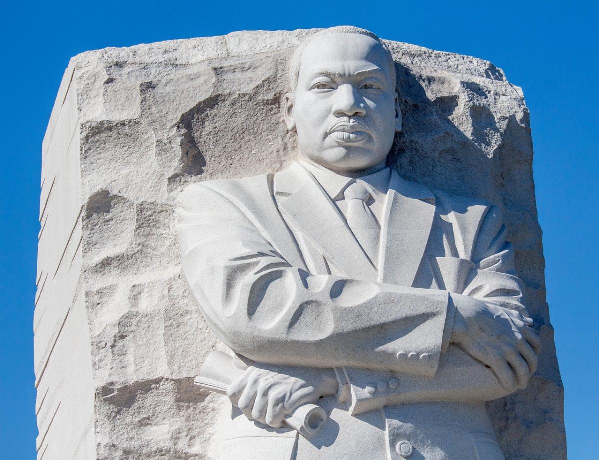 Dr. Martin Luther King Jr.'s monument from the waist up against a beautiful blue sky.